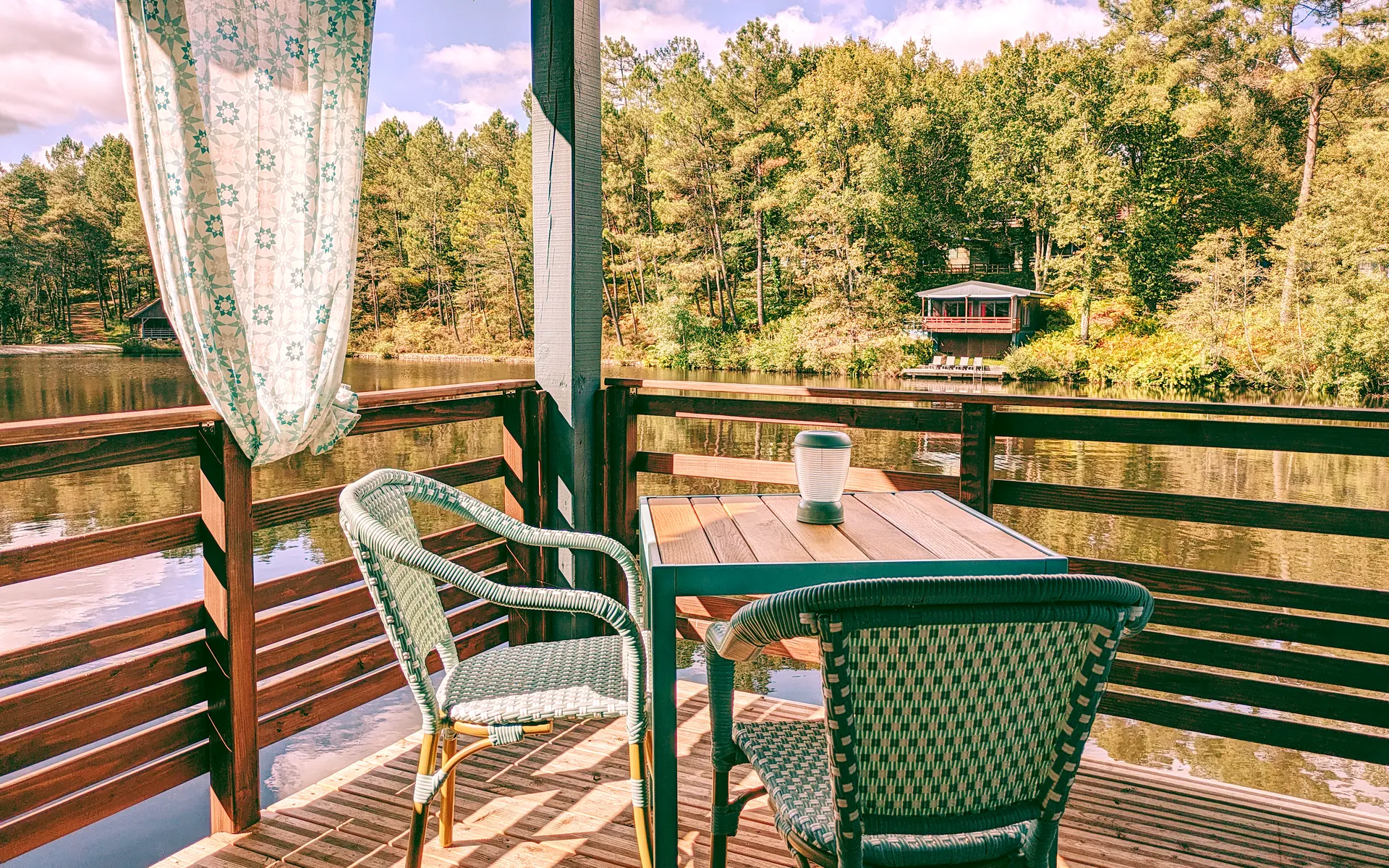 hébergements insolite terrasse couverte du chalet lacustre avec vue sur le lac en Dordogne