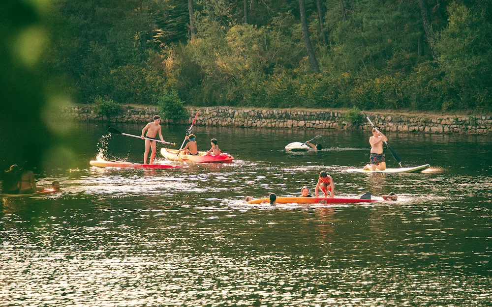 Personnes qui s'amusent sur les embarcations du lac de baignade